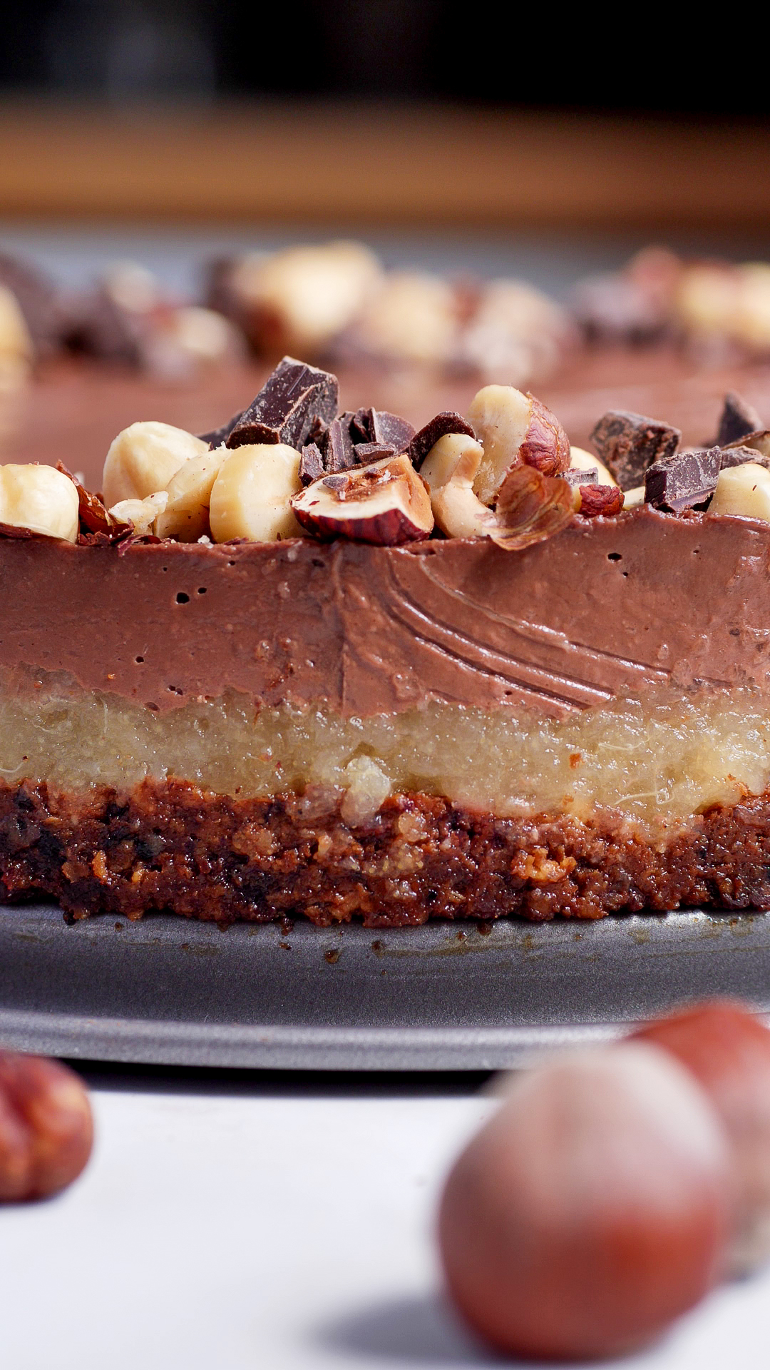 Tarte au Chocolat mit Birnenkompott und Haselnussboden von der Seite fotografiert