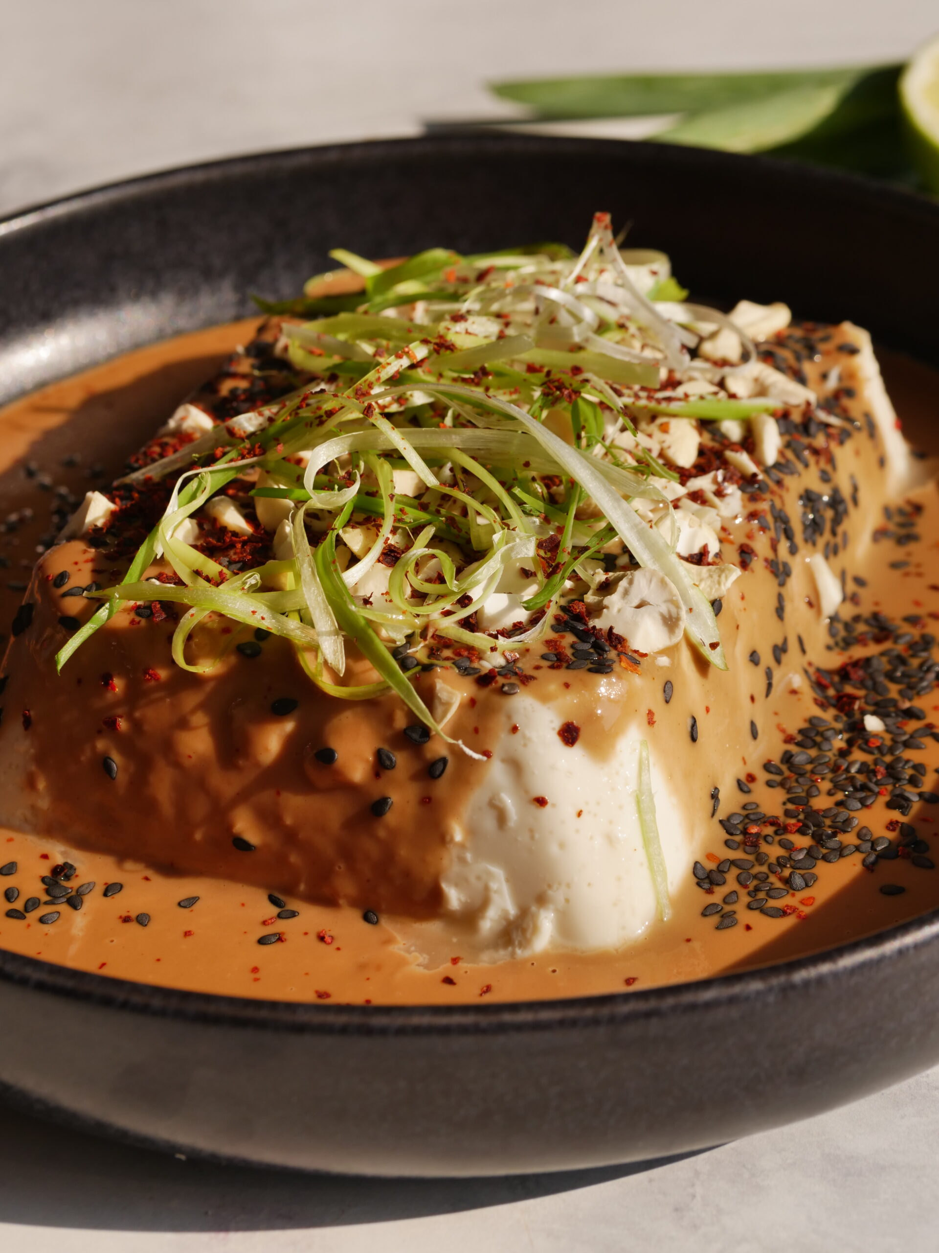 kalter Seidentofu mit pikanter Sauce aus Tahin und Erdnuss